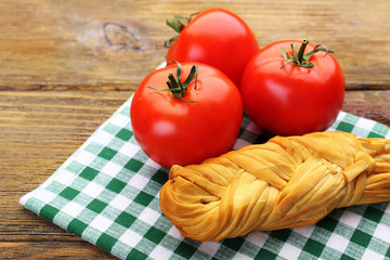 Smoked braided cheese on wooden table