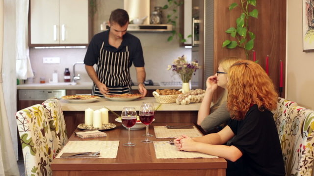Man preparing lunch for women at home