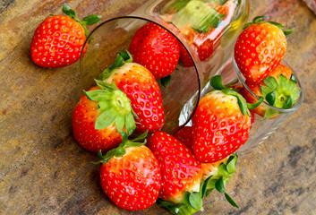 close up of fresh strawberries on the table and inside plastic b