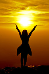 Fototapeta premium The success concept of silhouette of Young woman standing arms m