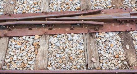 Close up of train track, spike, and wooden railroad tie.