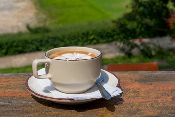 A cup of hot coffee on old wooden