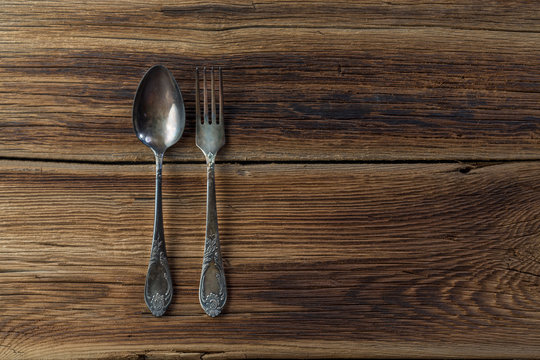 spoon with a fork on a wooden background