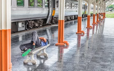 Papier Peint photo Gare man sleep in Passenger platform at  the railway station