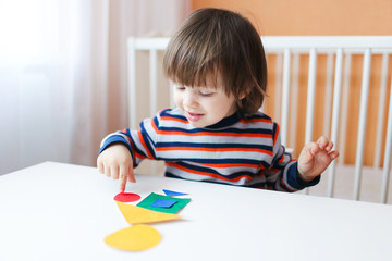 Lovely boy playing with geometric figures