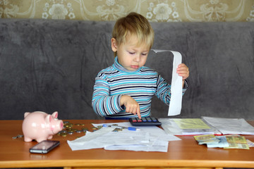 little boy is engaged in home accounting - 74064957