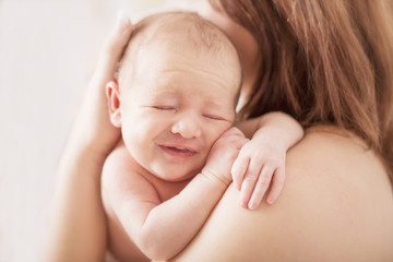 Newborn kleines Mädchen schlafend auf Mamas Schulter