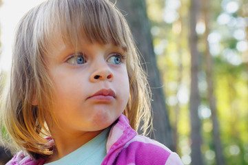Portrait of cute, serene and intrigued little girl in nature