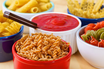 Variety of uncooked italian pasta on wooden table
