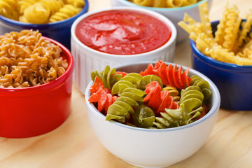 Variety of uncooked italian pasta on wooden table