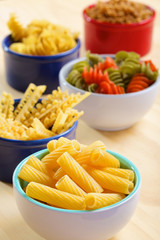 Variety of uncooked italian pasta on wooden table