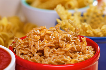 Variety of uncooked italian pasta on wooden table