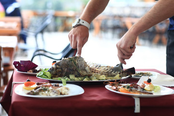 fish restaurant, fish is cut, the waiter hands