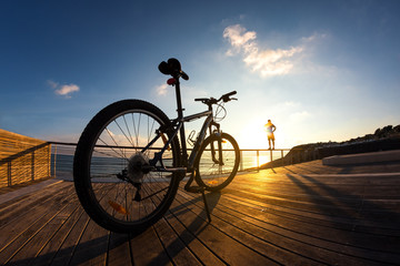 silhouette of  sportsman and mountain bike at the sunset
