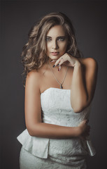 Portrait of beautiful young girl in a white dress