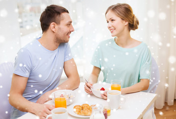 Obraz na płótnie Canvas smiling couple having breakfast at home