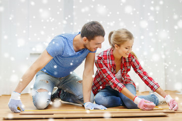 Obraz premium smiling couple measuring wood flooring
