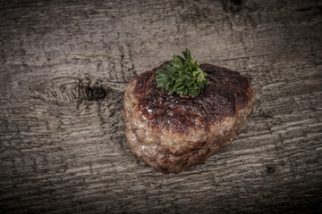 cutlet with parsley leaves on old wooden table