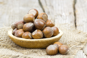 hazelnuts in a bowl on old wooden background