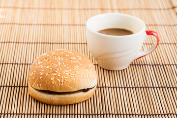hamburgers and cup of black coffee on wooden board.