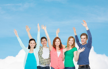 group of smiling students waving hands