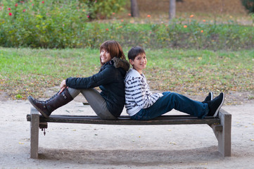 Teenage boy and girl having fun in the park on beautiful autumn