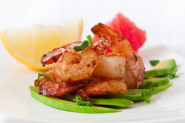 Shrimp sauteed with garlic and soy sauce on a cushion of avocado