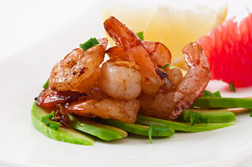 Shrimp sauteed with garlic and soy sauce on a cushion of avocado