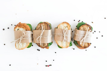 Hühnchen-Spinat-Sandwiches, eingewickelt in Kraftpapier über einem Wh