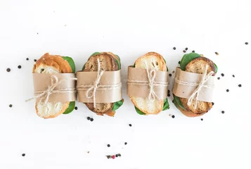Foto auf Acrylglas Produktauswahl Hühnchen-Spinat-Sandwiches, eingewickelt in Kraftpapier über einem Wh