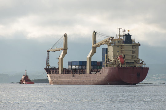 tow boat is towing the tanker from the port