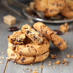 Stacked chocolate chip cookies on rustic wooden background