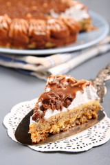 Almond cake with chocolate and cream on gray background