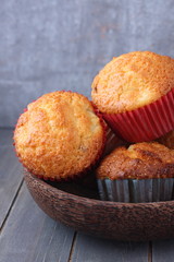 Homemade muffins with raisins on wooden plate