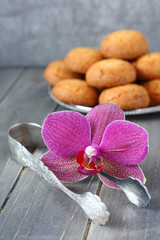 Sugar tongs and orchid flower with almond cookies