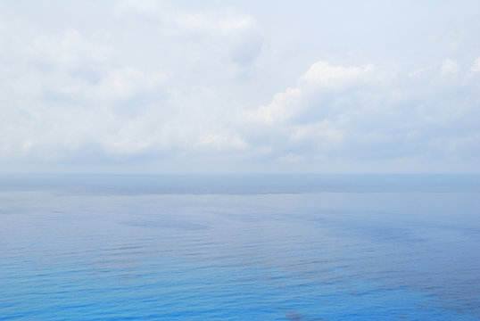 Blue open sea water under cloudy sky