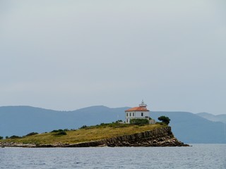 Fototapeta na wymiar The Plocica lighthouse on a small island in the Adriatic sea