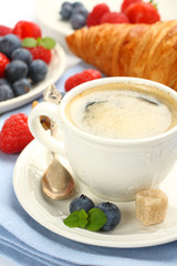 Breakfast with cup of coffee, croissants and berries