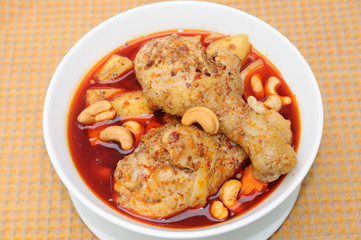 Fototapeta premium Chicken Mussaman Curry on orange plate mat.