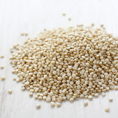 Uncooked quinoa seed grain on white wooden background