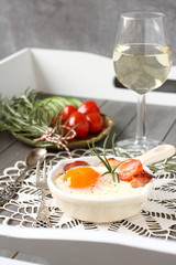 Breakfast on wooden tray, fried egg with bacon and vegetables