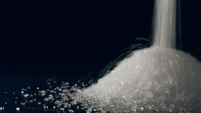 Pouring sugar on black background