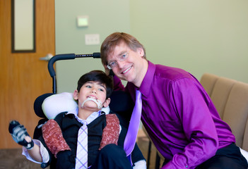 Caucasian father in purple dresshirt and necktie sitting next to