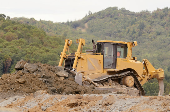 Large bulldozer leveling out fill at a airport runway 