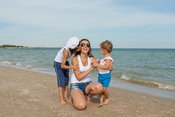 Mother and her two sons having fun on the beach