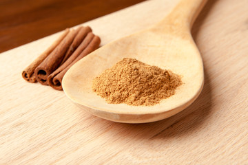 cinnamon sticks and cinnamon powder on a wooden spoon