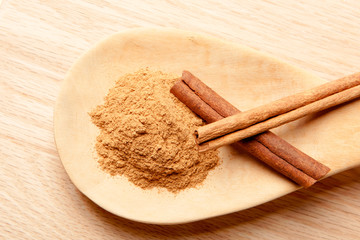 cinnamon sticks and cinnamon powder on a wooden spoon