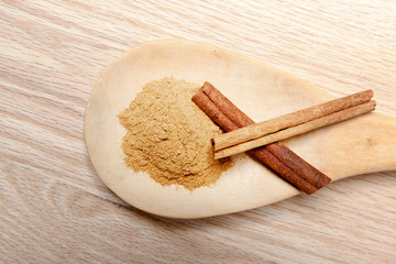 cinnamon sticks and cinnamon powder on a wooden spoon