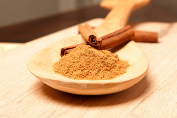 cinnamon sticks and cinnamon powder on a wooden spoon