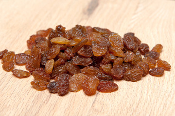 Raisins on wood plank, background